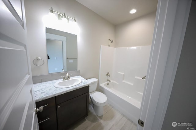 full bath featuring shower / washtub combination, vanity, toilet, and recessed lighting