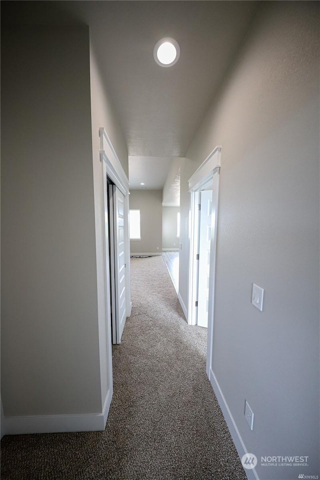 hallway with carpet and baseboards