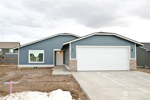 view of front of house with an attached garage, stone siding, and concrete driveway