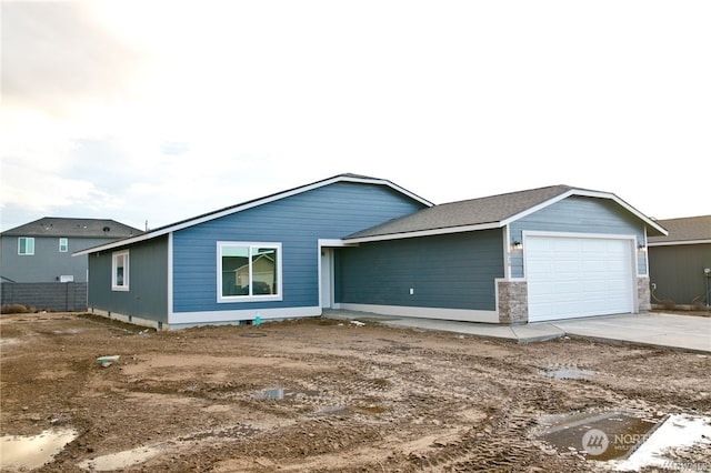 view of front of house featuring concrete driveway, fence, and an attached garage