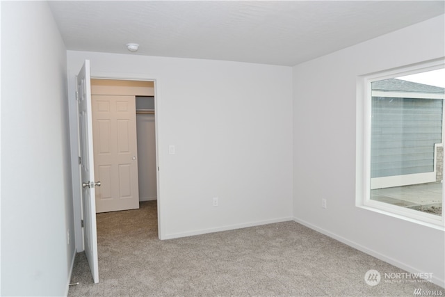 unfurnished room featuring carpet and baseboards