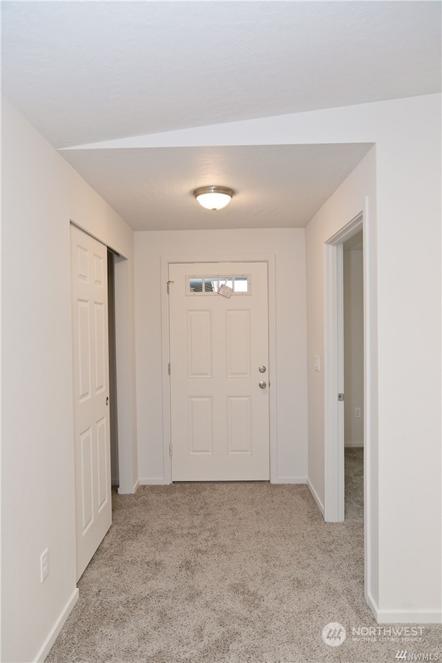 foyer entrance with carpet floors and baseboards