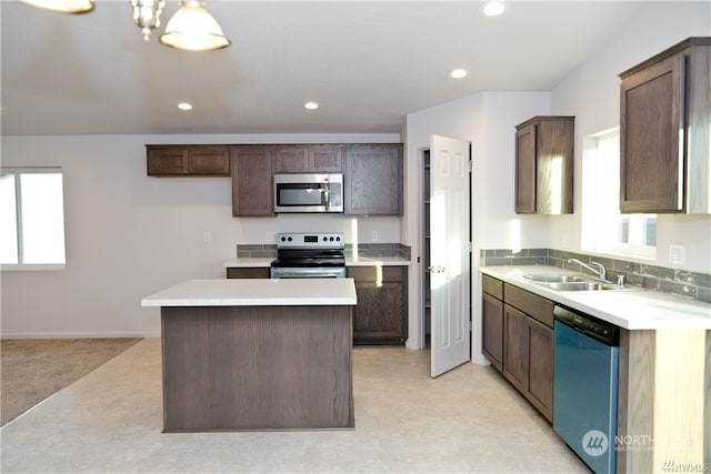 kitchen featuring a wealth of natural light, a kitchen island, stainless steel appliances, and a sink