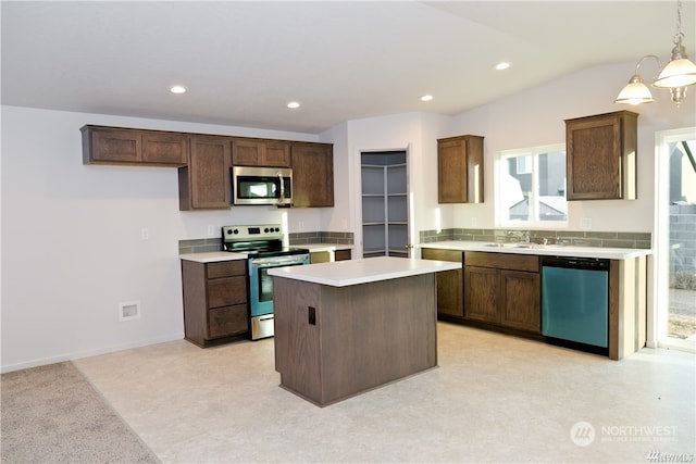 kitchen featuring appliances with stainless steel finishes, a center island, light countertops, a sink, and recessed lighting