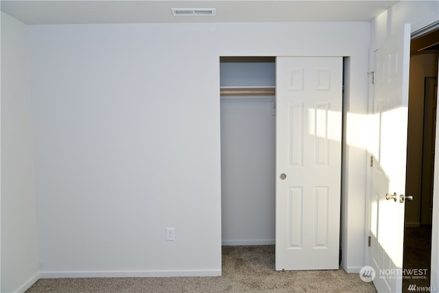 unfurnished bedroom with carpet floors, a closet, visible vents, and baseboards