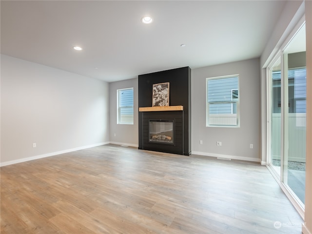 unfurnished living room with light wood-type flooring and a fireplace