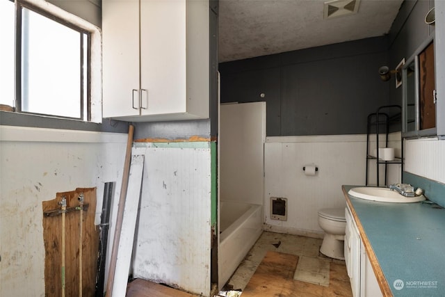 bathroom with vanity, toilet, and a bathing tub