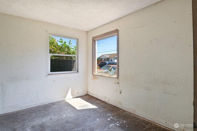 unfurnished room with a textured ceiling