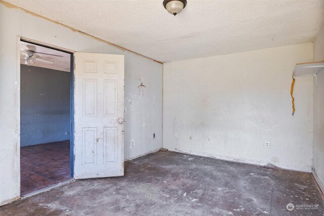 unfurnished room featuring a textured ceiling