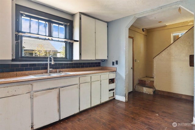 kitchen with sink, white cabinets, tasteful backsplash, and dark hardwood / wood-style flooring