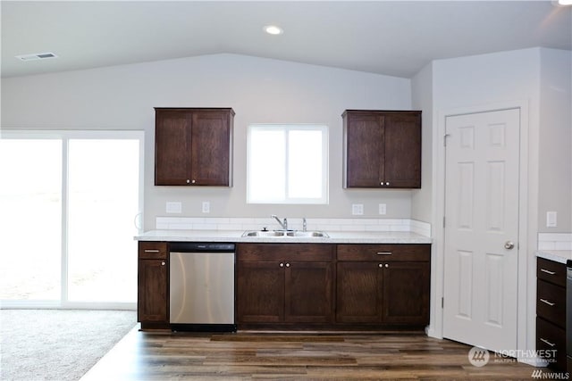 kitchen with dark brown cabinetry, visible vents, dishwasher, vaulted ceiling, and a sink