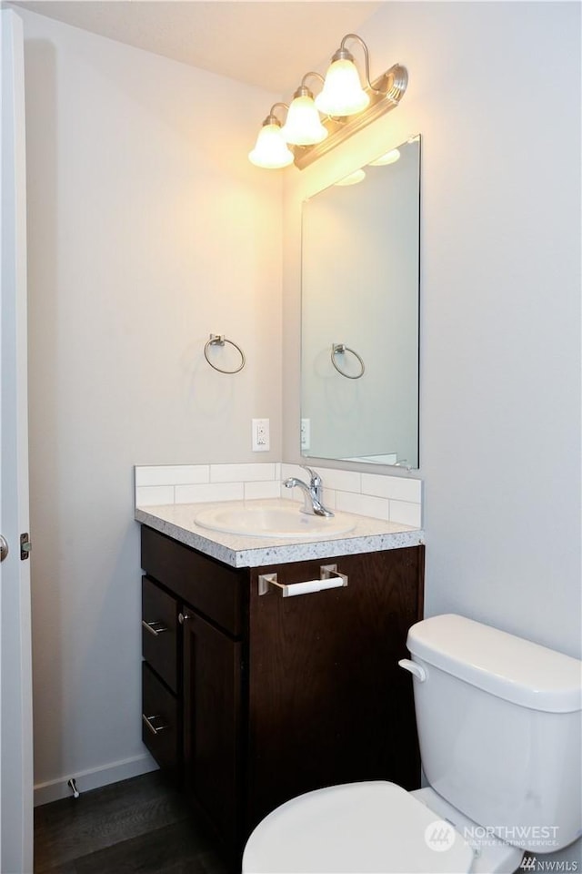 half bathroom with toilet and vanity