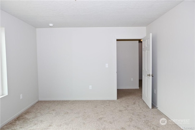 carpeted spare room with baseboards and a textured ceiling