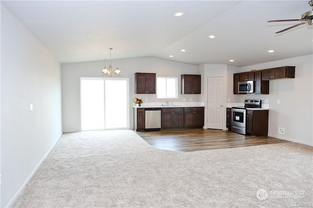 kitchen with stainless steel appliances, dark colored carpet, and open floor plan