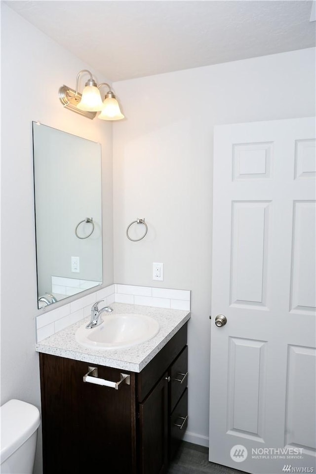 bathroom featuring vanity and toilet