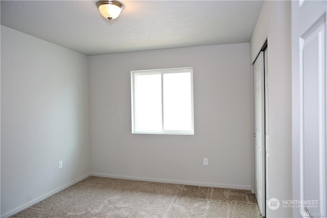 unfurnished bedroom with carpet floors, baseboards, and a closet