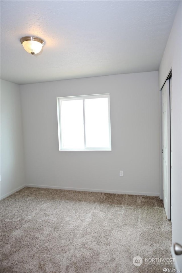 unfurnished bedroom featuring a closet, carpet flooring, and baseboards