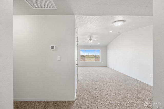 spare room featuring carpet flooring, ceiling fan, visible vents, and baseboards