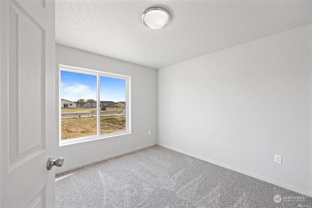 carpeted spare room with baseboards