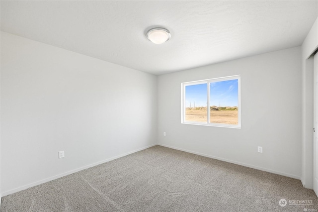 empty room with baseboards and carpet flooring