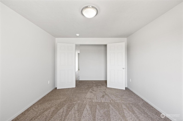 unfurnished bedroom featuring carpet floors and baseboards