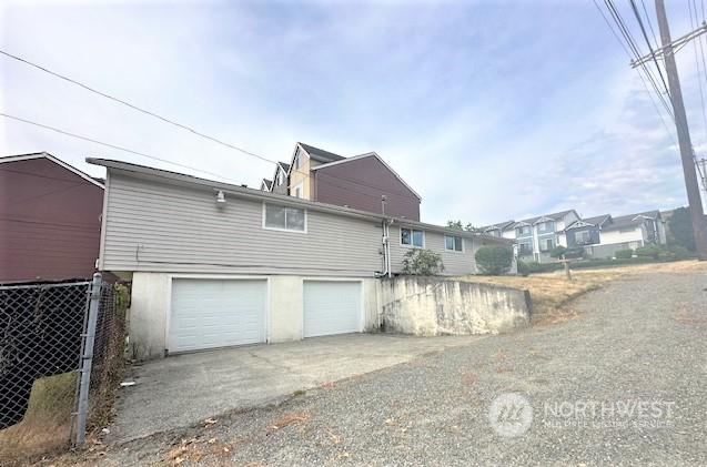 view of side of home featuring a garage and driveway