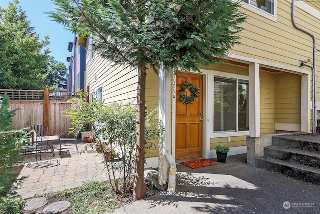 view of exterior entry with a patio