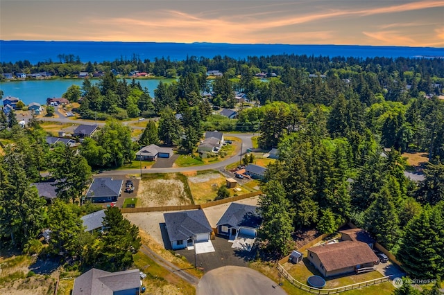 aerial view at dusk featuring a water view