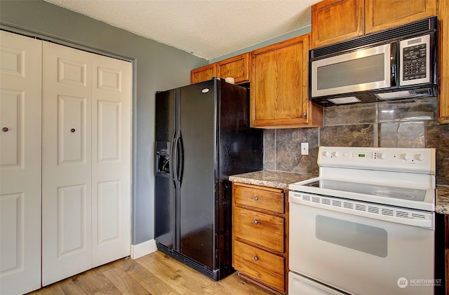 kitchen with white electric range, backsplash, light hardwood / wood-style floors, and black fridge with ice dispenser