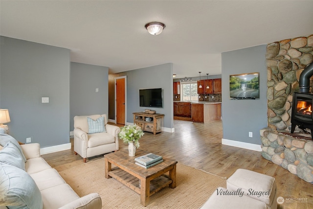 living room featuring light hardwood / wood-style floors and a wood stove