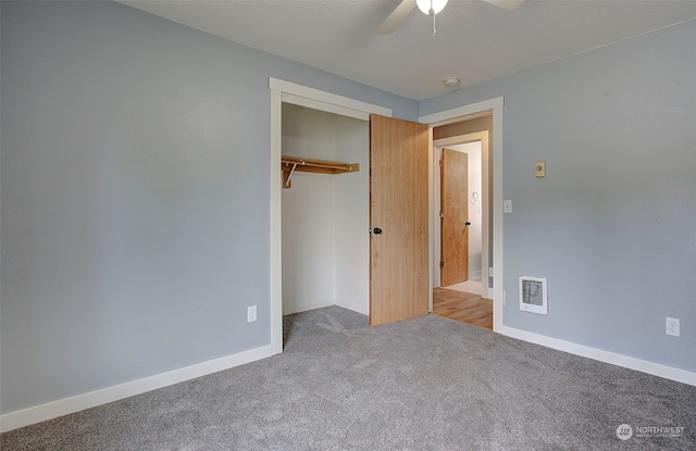 unfurnished bedroom featuring a closet, light colored carpet, and ceiling fan