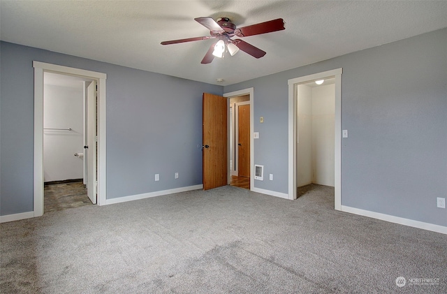 unfurnished bedroom with carpet floors, ceiling fan, and a spacious closet