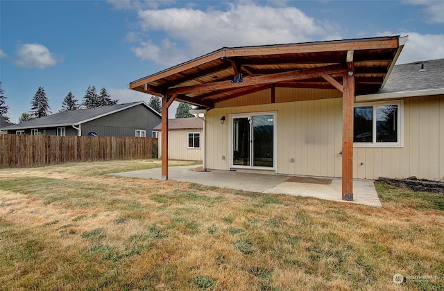 rear view of property featuring a lawn and a patio area