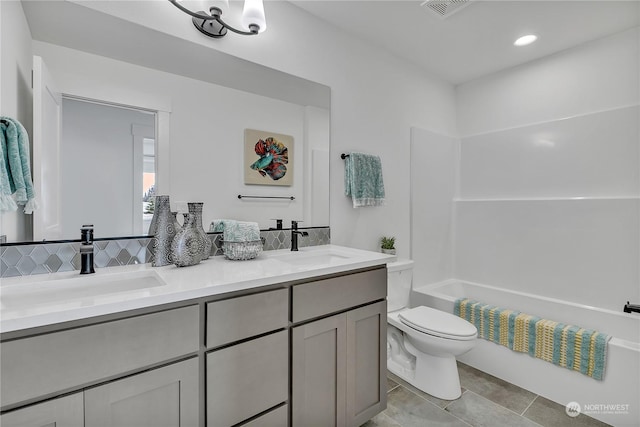 bathroom featuring visible vents, a sink, toilet, and double vanity