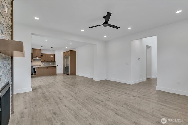16224 76th Avenue Ct E, Puyallup, WA 98375 - unfurnished living room featuring ceiling fan, recessed lighting, light wood-style floors, baseboards, and a stone fireplace