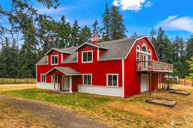 view of front of home with a garage, a front yard, and a deck