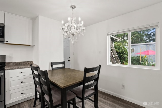 dining room with dark hardwood / wood-style flooring and a chandelier