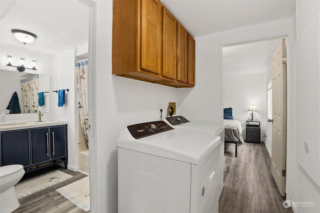 washroom featuring washer and dryer, sink, and hardwood / wood-style floors