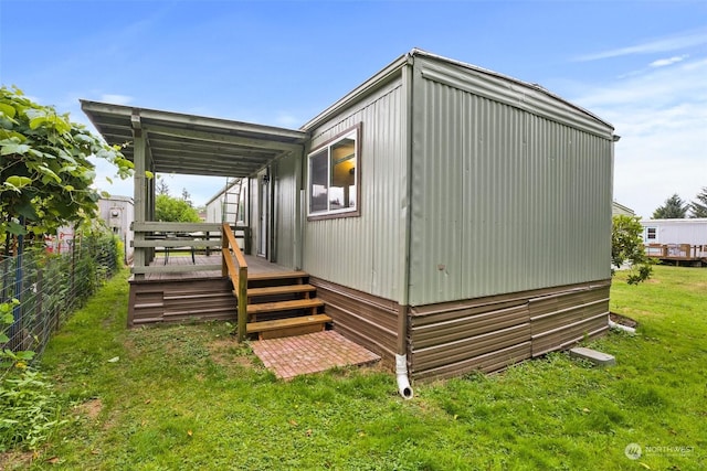 rear view of property featuring a lawn and a deck