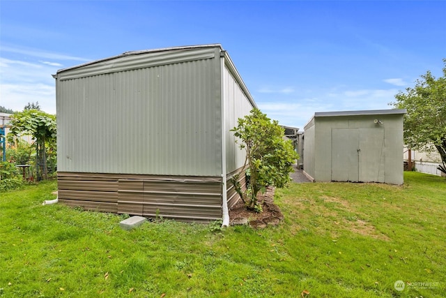 view of home's exterior with a lawn and a storage unit