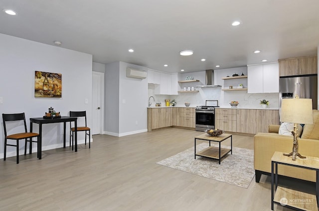 living room with sink, light hardwood / wood-style flooring, and a wall unit AC