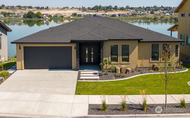 view of front of property with a water view, a garage, and a front lawn