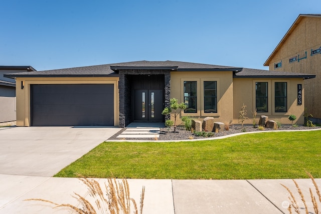 prairie-style home with a garage and a front yard