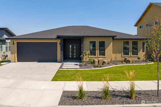 prairie-style home with a garage and a front yard