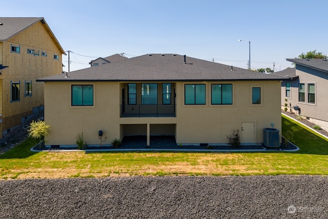 rear view of house featuring cooling unit and a yard