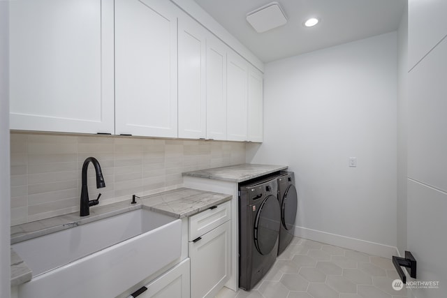 laundry area featuring cabinets, light tile patterned flooring, sink, and washer and clothes dryer