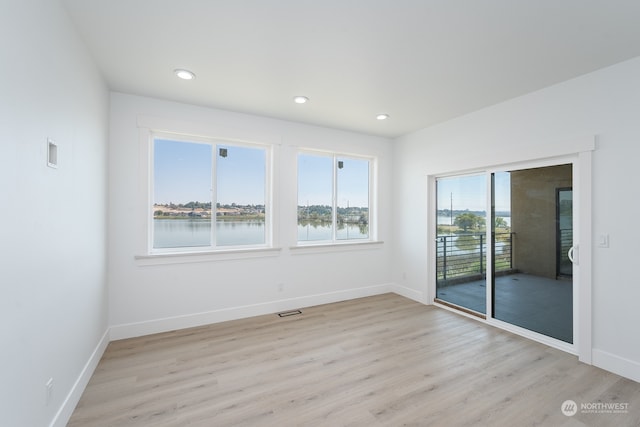 empty room with a water view and light wood-type flooring