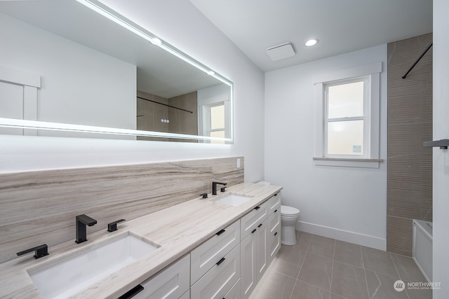 full bathroom with vanity, tiled shower / bath, tile patterned floors, and toilet