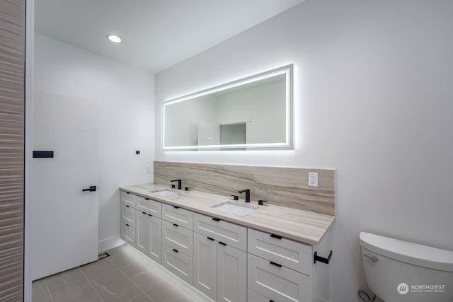 bathroom featuring tile patterned flooring, vanity, decorative backsplash, and toilet