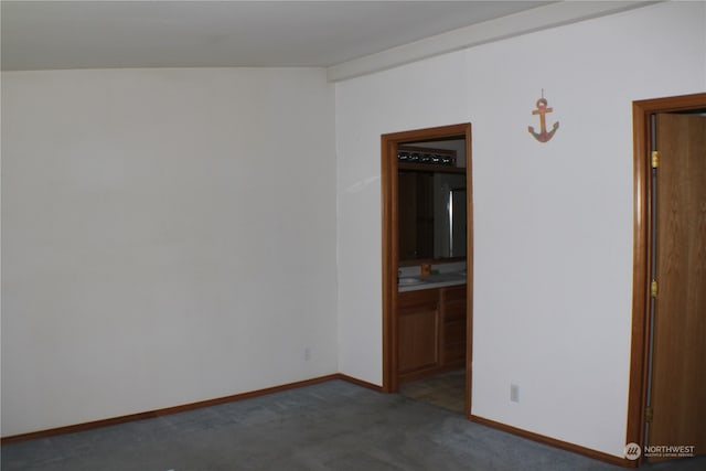 unfurnished room with sink, carpet floors, and vaulted ceiling